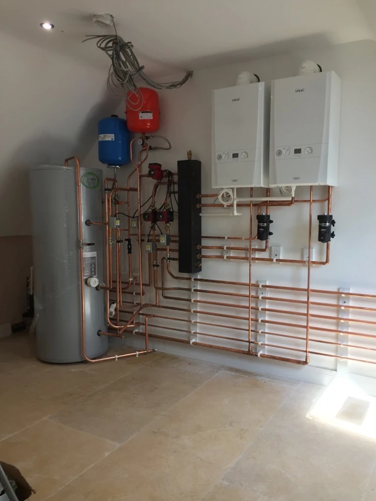 Full plant room with copper pipework, cylinders and wall-mounted units