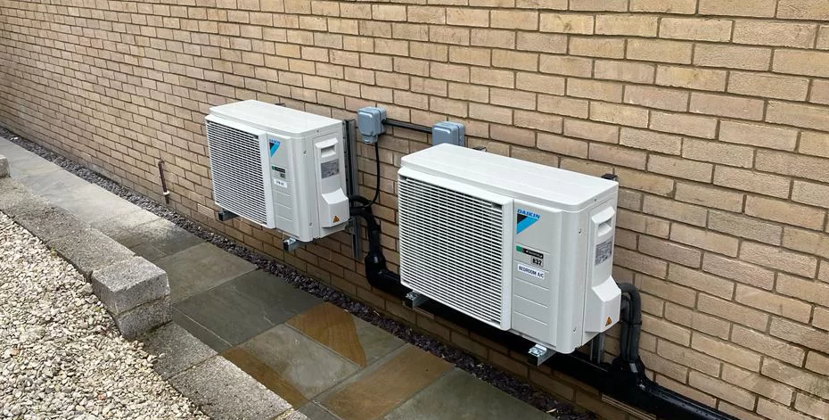 Two Daikin air conditioning outdoor units wall-mounted on brackets