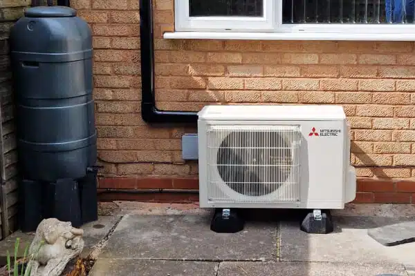Mitsubishi Electric air conditioning outdoor unit installed against a brick wall