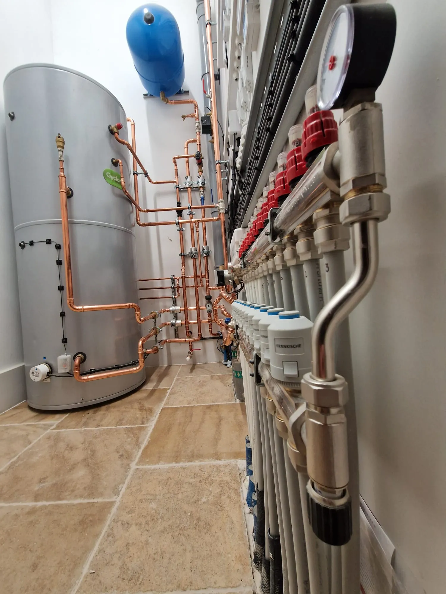 Plant room with cylinder, copper pipework and underfloor heating manifold