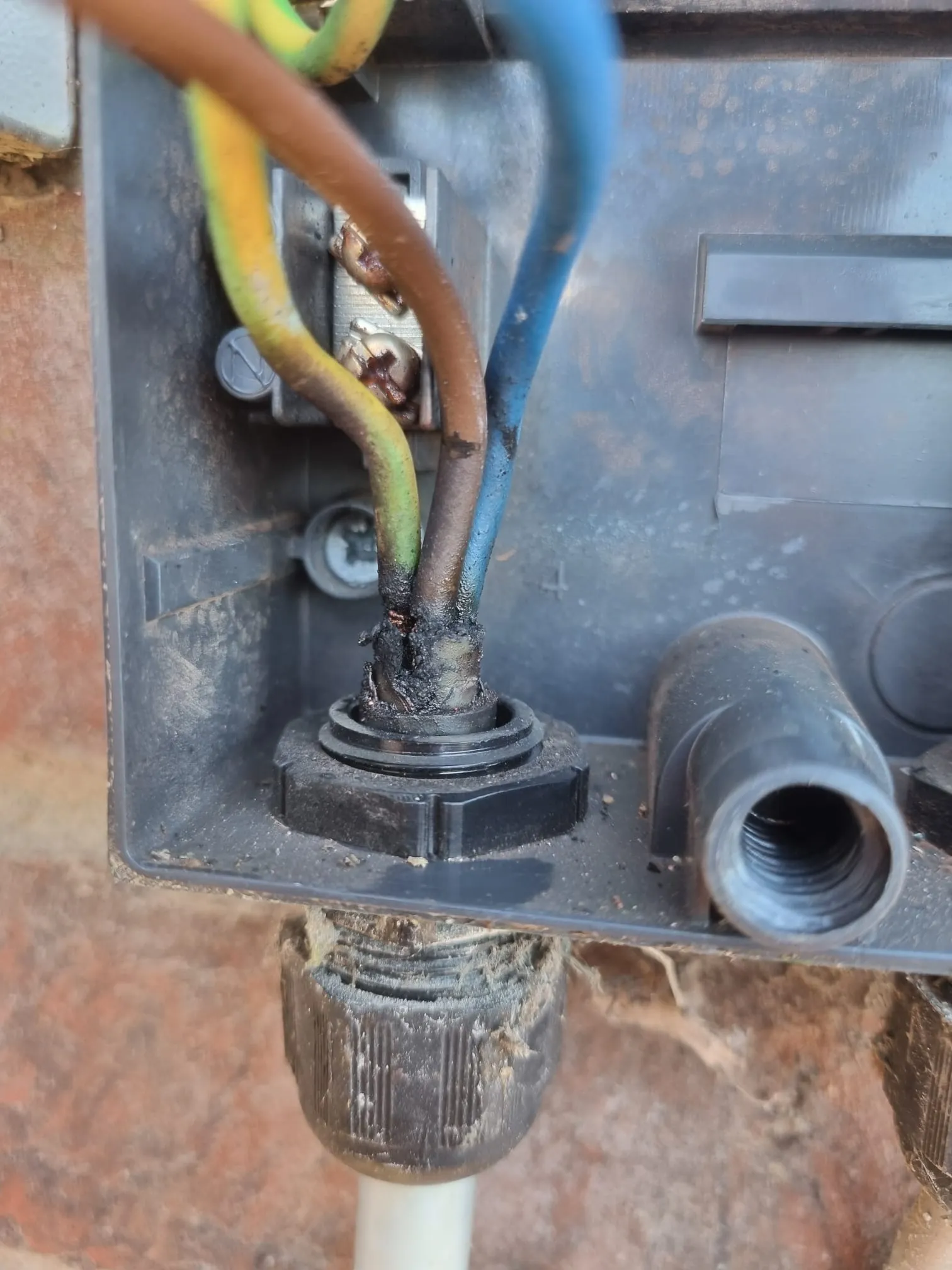Damaged wiring junction box on a heat pump outdoor unit