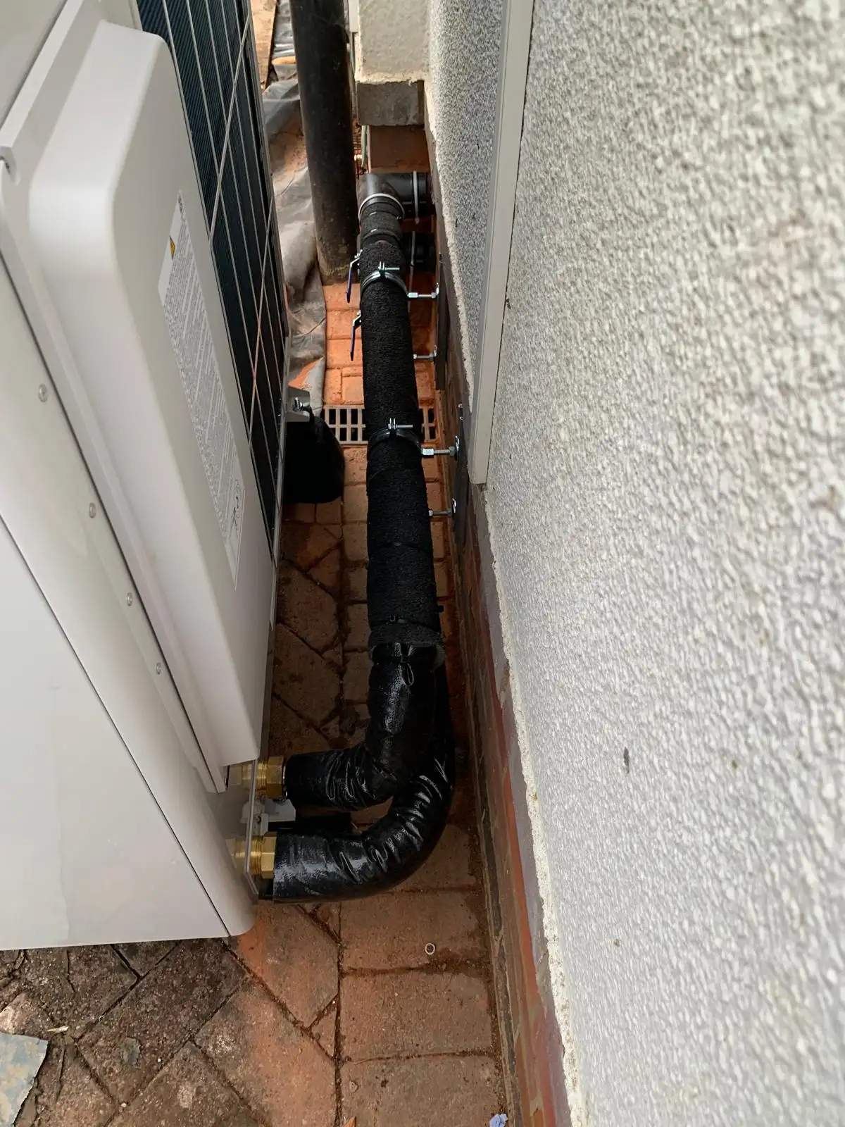 Heat pump outdoor unit with insulated flow and return pipework