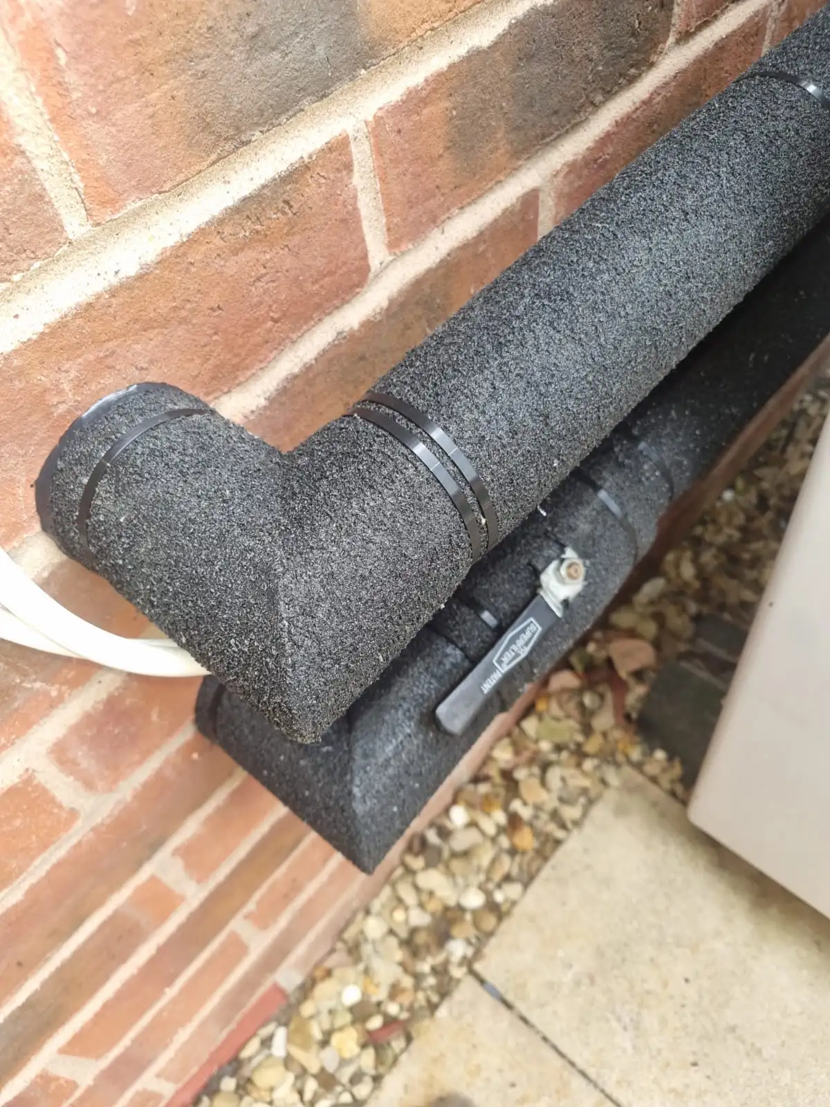 Insulated pipe T-junction on a heat pump outdoor unit