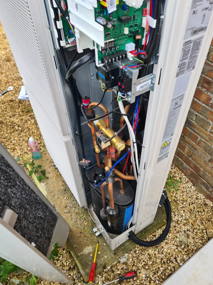 Heat pump outdoor unit with panels removed exposing internals during service