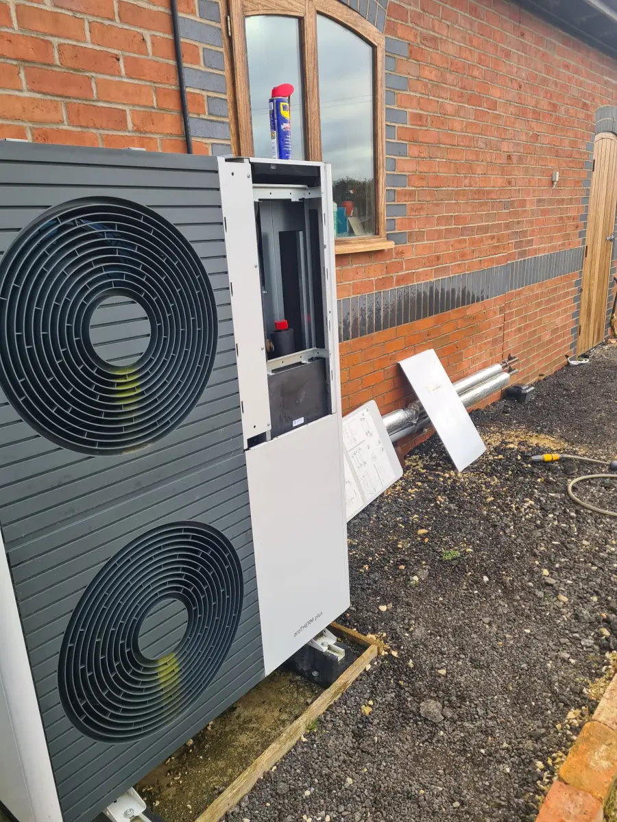 Large air source heat pump with front panel removed during maintenance