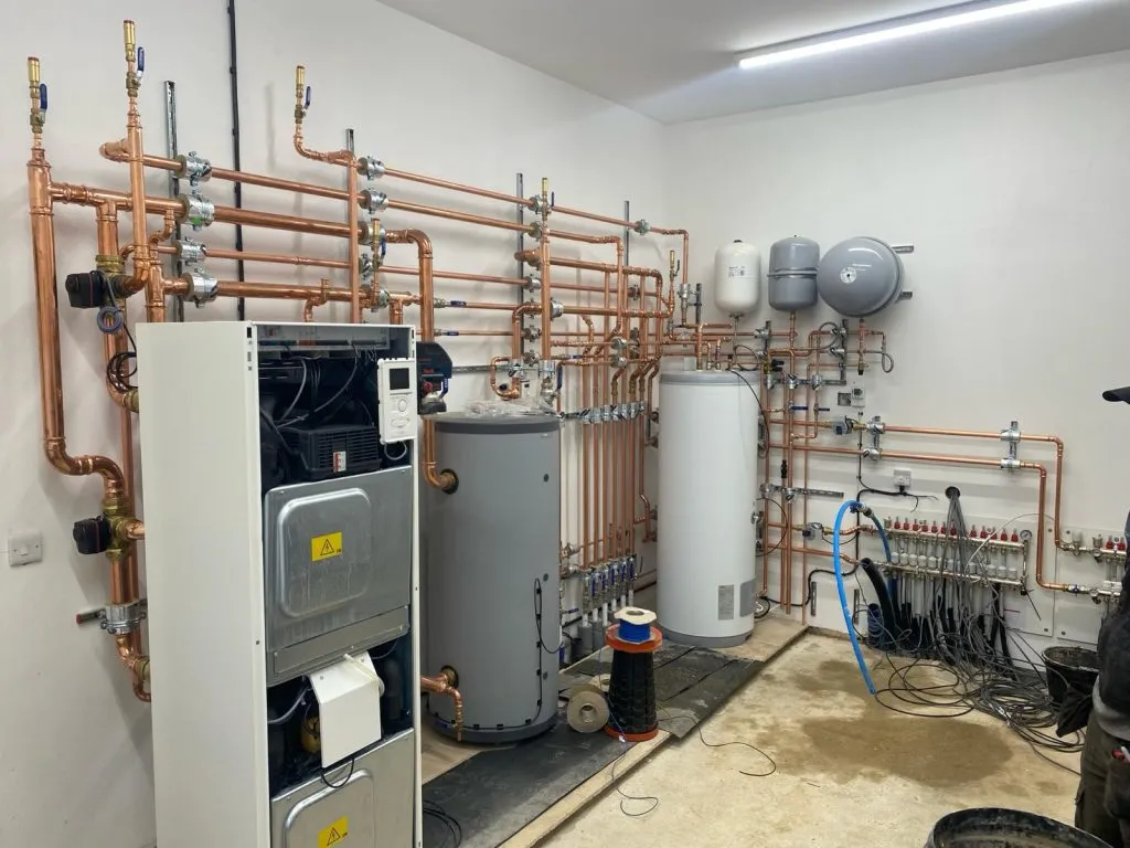 Ground source heat pump plant room with copper pipework and cylinders