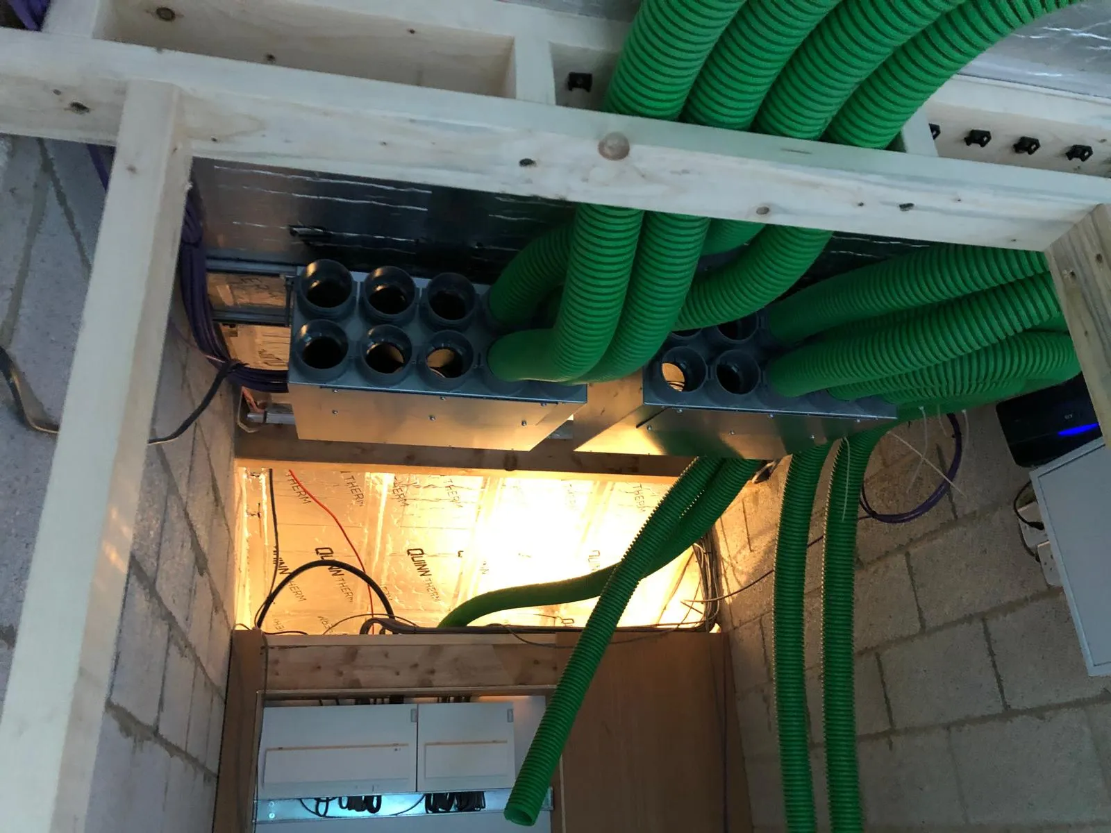 MVHR duct manifold with green semi-rigid ducts in a new build